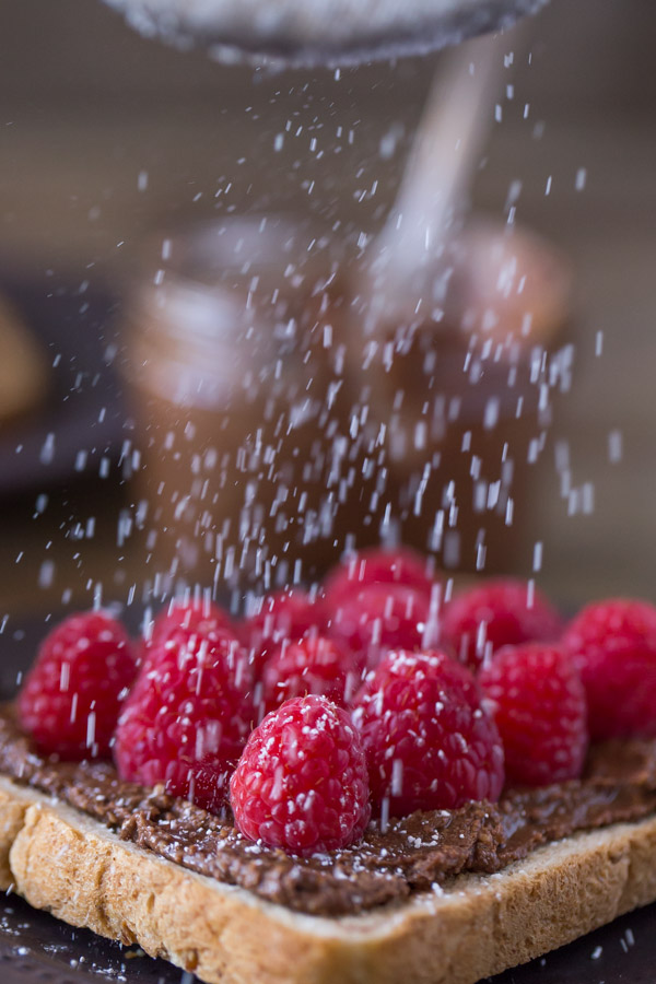 Chocolate Hazelnut Raspberry Toast being sprinkled with powdered sugar.