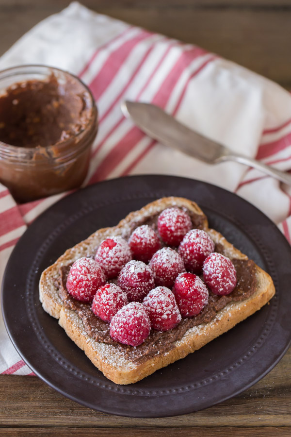 Chocolate Hazelnut Raspberry Toast - Homemade chocolate hazelnut spread on toast with fresh raspberries and powdered sugar.