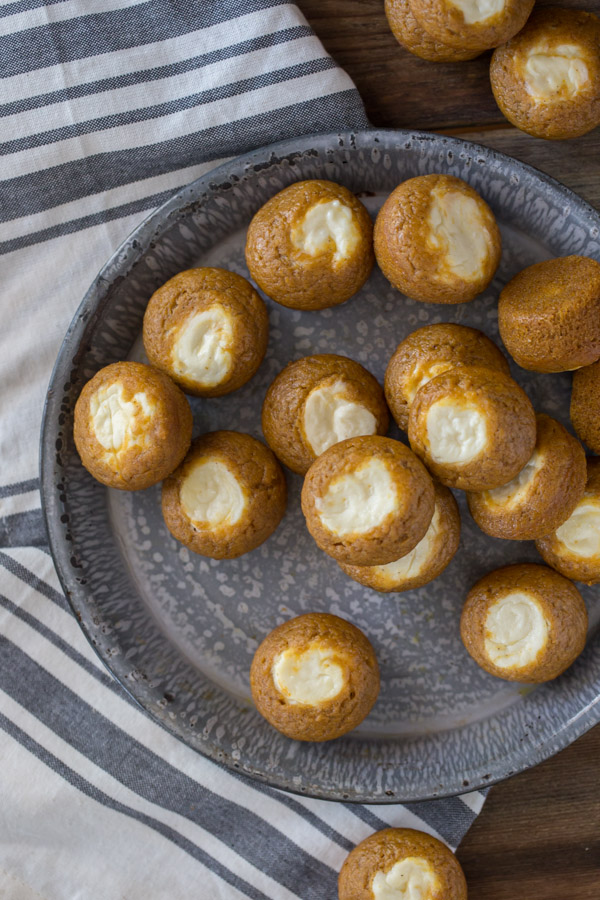 Mini Pumpkin Cheesecake Muffins - Super pop-able, bite sized pumpkin muffins with a creamy cheesecake center. 
