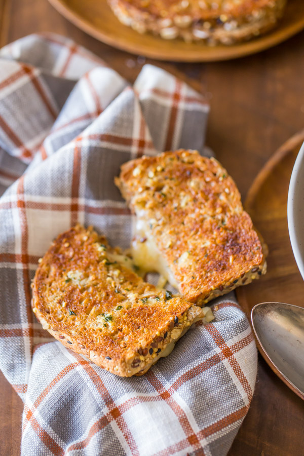 A Garlic Bread Toasted Cheese Sandwich cut in half, siting on a cloth napkin.