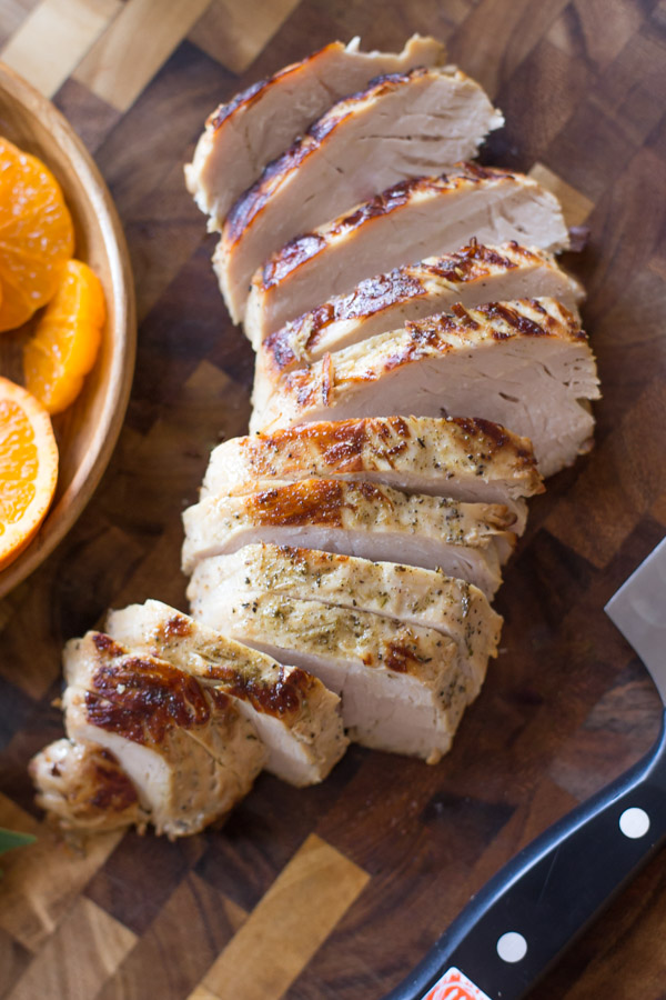 Sliced turkey tenderloin on a cutting board for the Turkey Farro Salad With Candied Chickpeas.