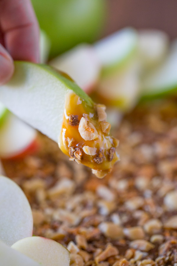 An apple slice that has been dipped into the Easy Caramel Apple Dip.