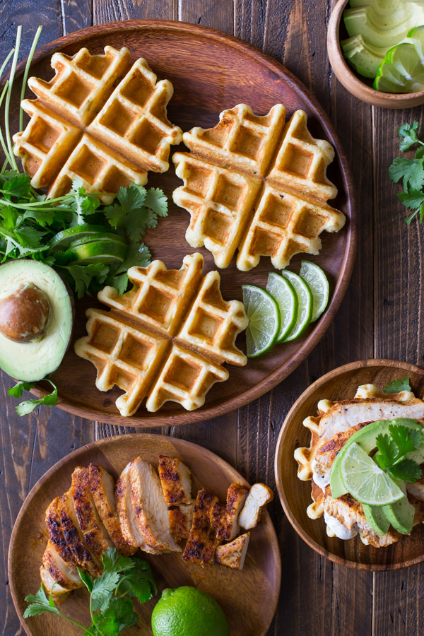 Green Chile Chicken Waffletada - A mini cornbread waffle served tostada style, topped with a green chile cream, grilled chicken, and avocado!