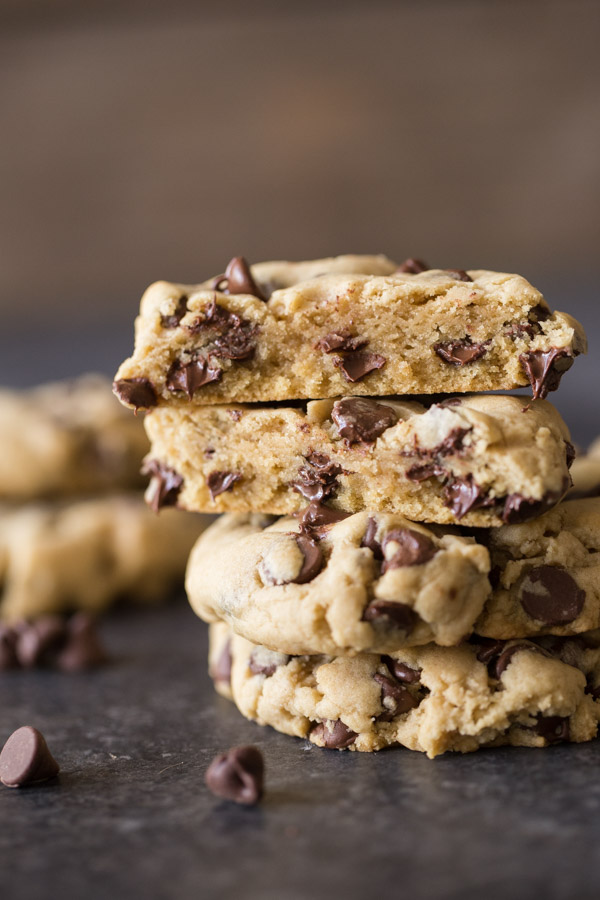 An Ultimate Chocolate Chip Cookie cut in half, stacked on top of two whole cookies.