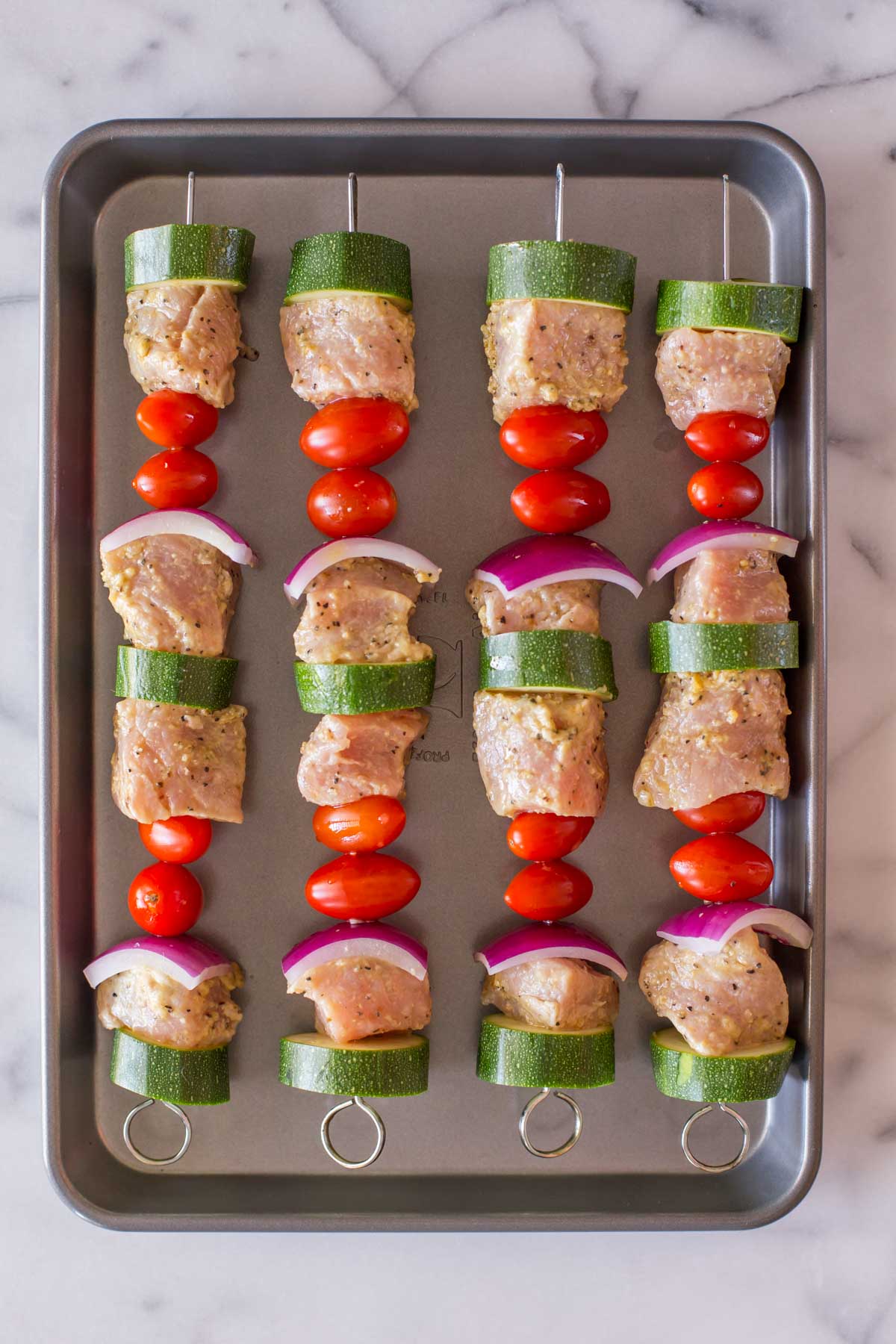 Pork Tenderloin Kabobs on a baking sheet before being grilled.