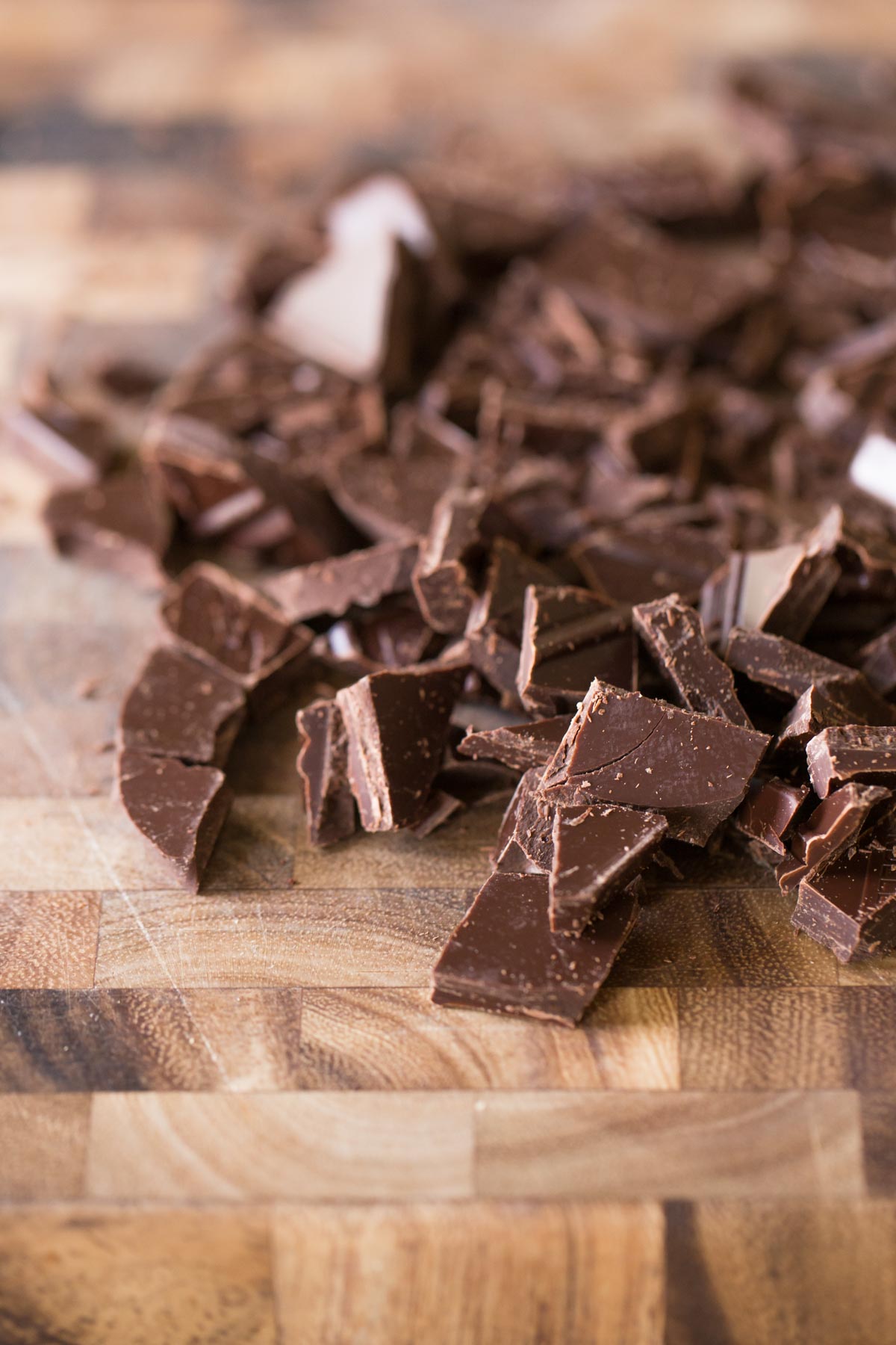 A cutting board with chopped bittersweet chocolate on it for the One Bowl Triple Chocolate Brownie Cookies.