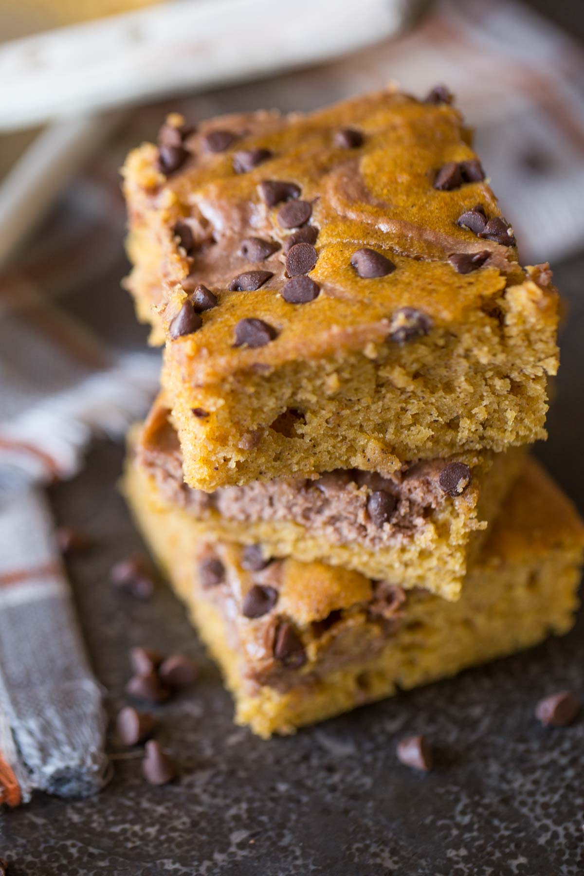 Three Chocolate-Swirled Pumpkin Bars stacked on top of each other.