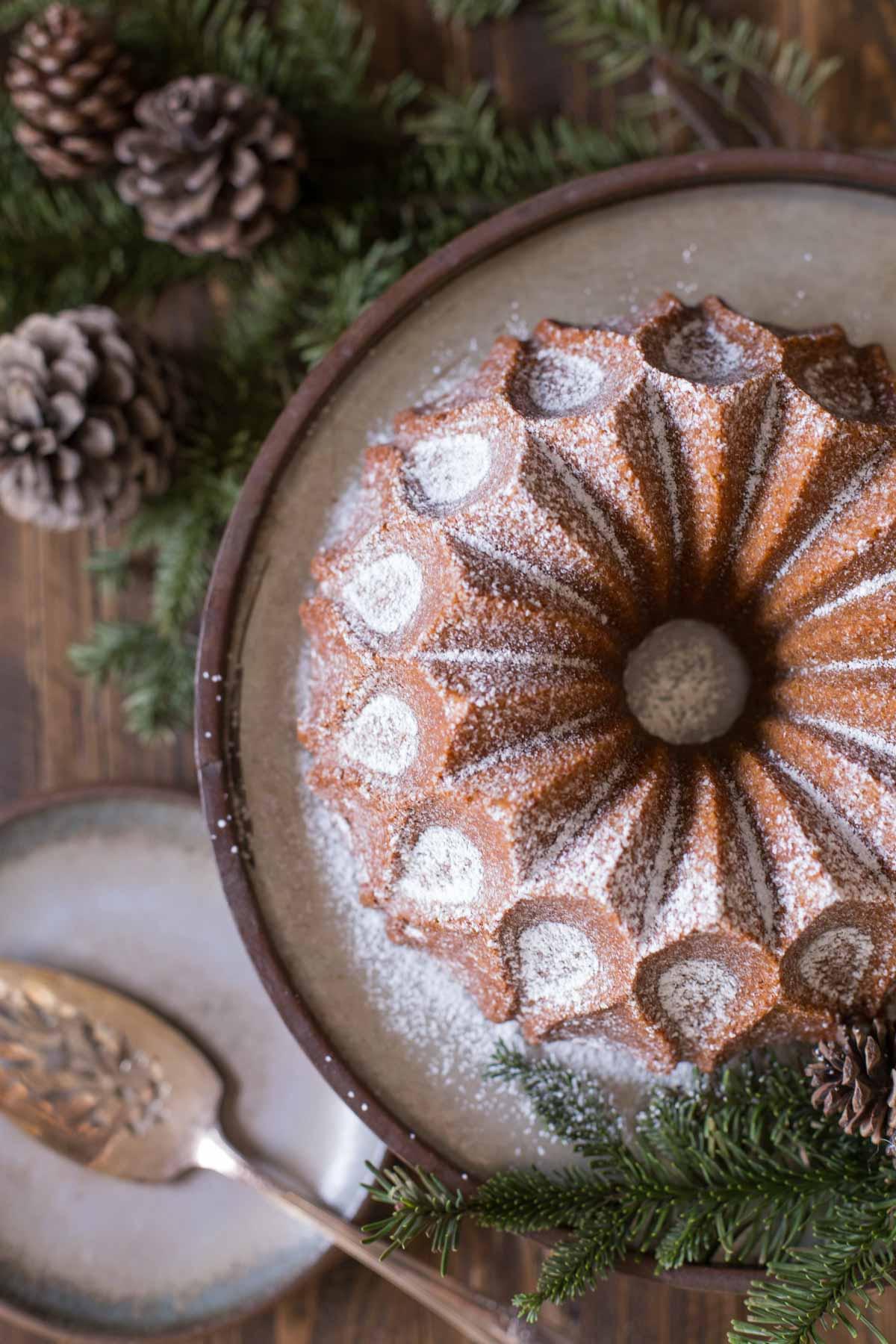 Gingerbread Bundt Cake on a cake stand, dusted with powdered sugar.