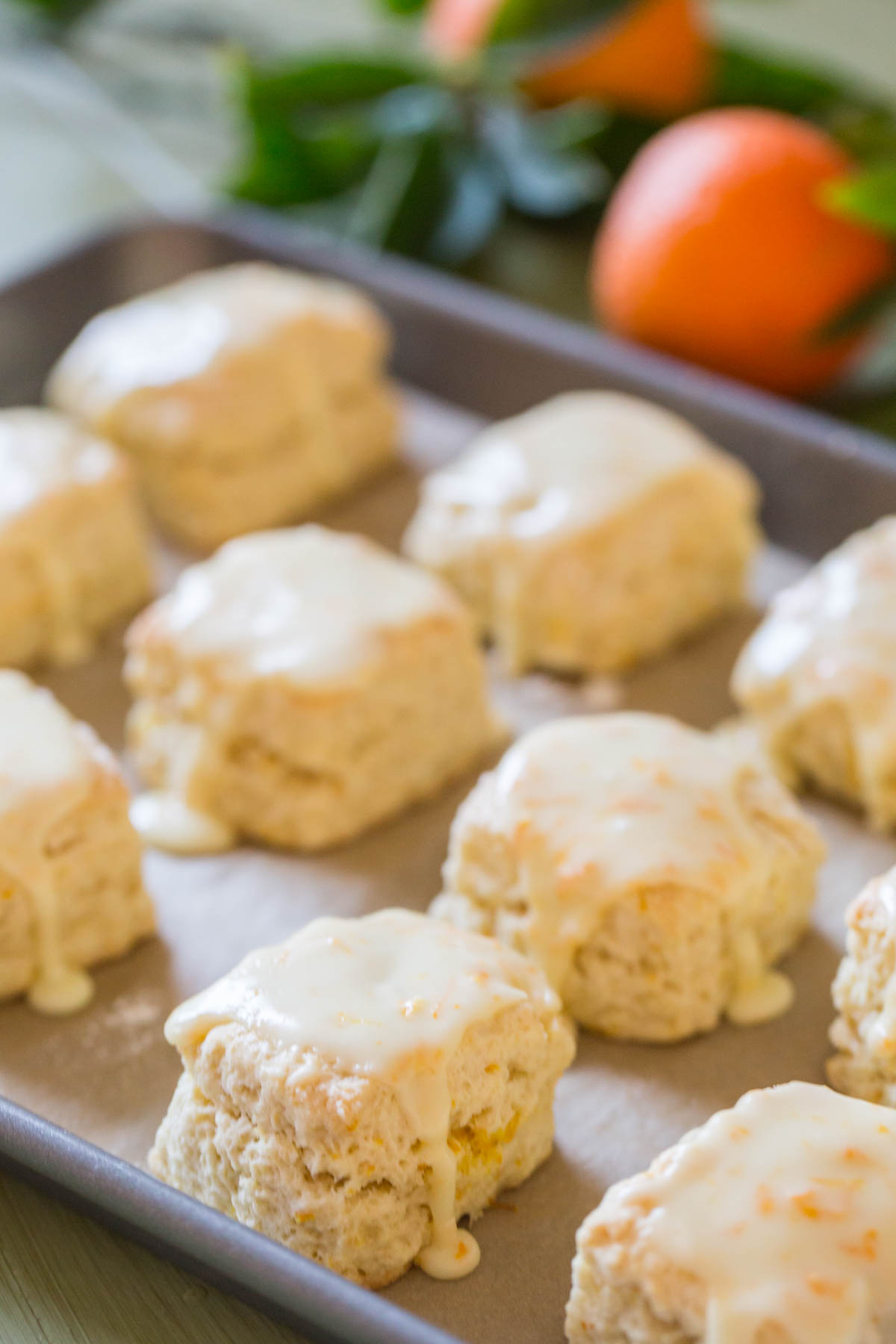 Mini Orange Cream Scones on a parchment paper lined baking sheet. 