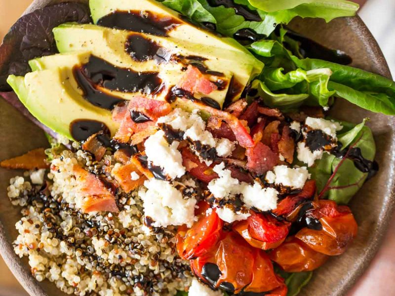 These BLT Bliss Bowls have so much going on! They've got mixed baby greens, oven roasted tomatoes, crisp bacon, avocado, nutty quinoa, and creamy feta.