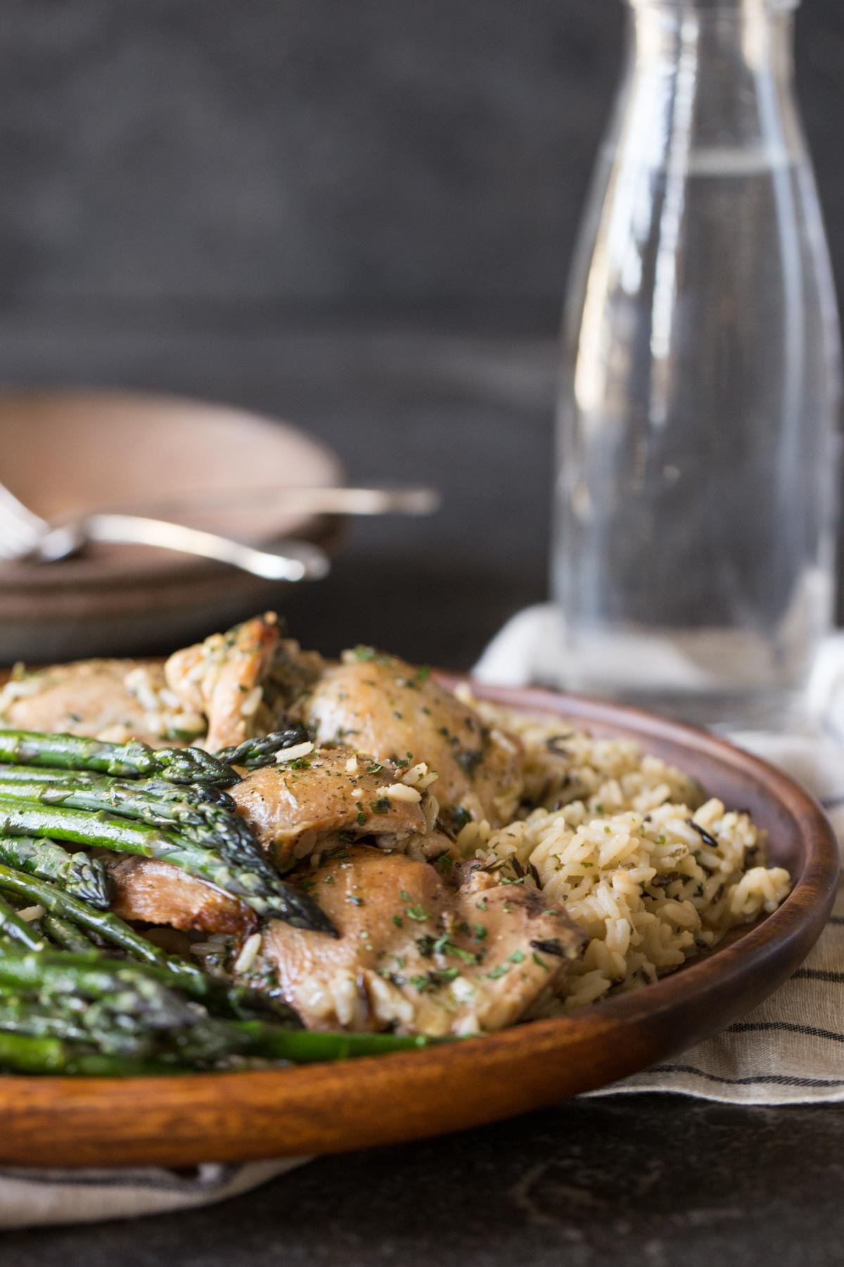 One Pot Chicken and Rice Dinner on a large serving plate, with some plates, forks and a glass in the background. 