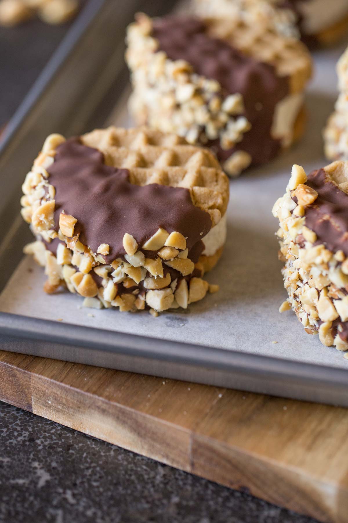 Peanut Butter Cookie Ice Cream Sandwiches on a parchment paper lined baking sheet. 