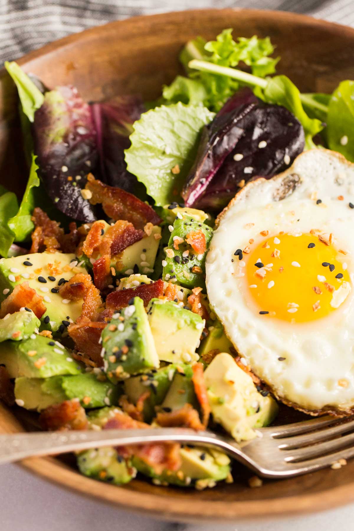 Avocado Breakfast Bowl in a wood bowl with a fork.  