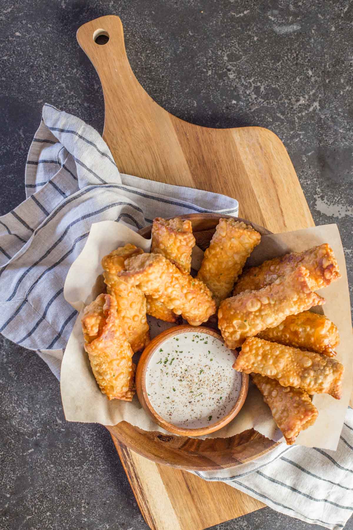 Fried Sloppy Joe Rolls in a wood bowl, along with a small wood bowl of ranch dip.