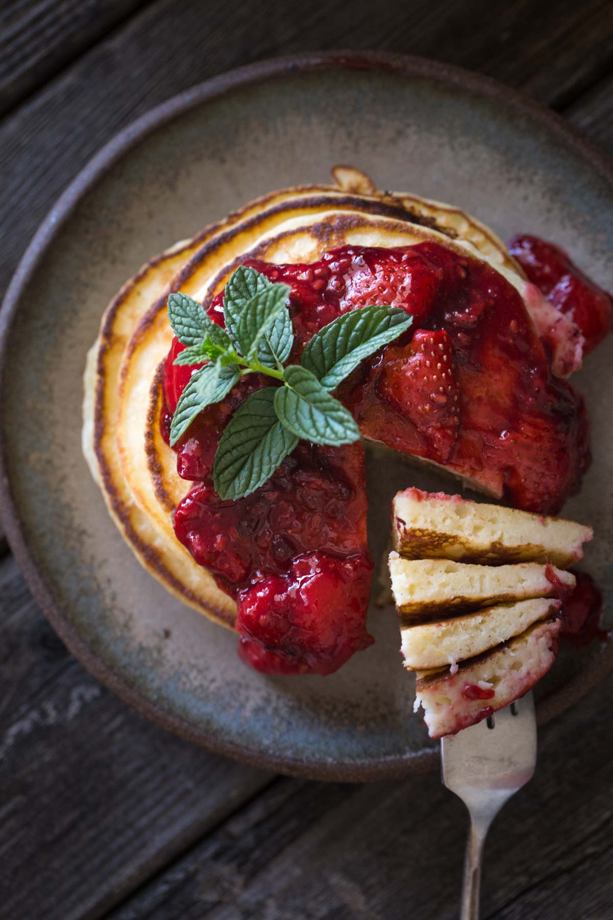 A top down view of a stack of Lemon Ricotta Pancakes with Fresh Berry Sauce.