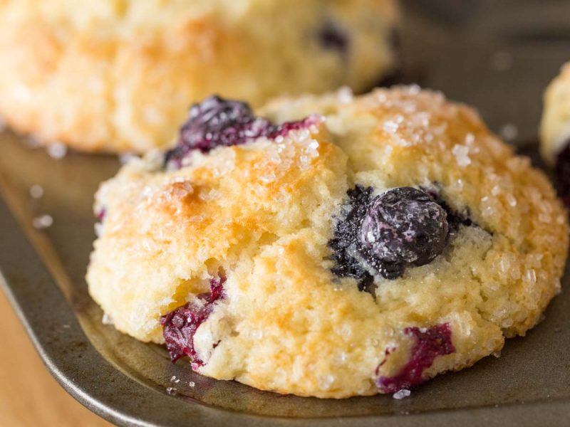 A close up view of Best Ever Buttermilk Blueberry Muffins in a muffin pan.