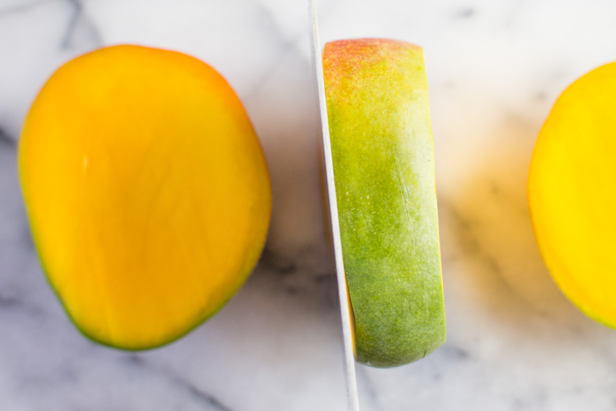 Cutting a mango on a marble cutting board.