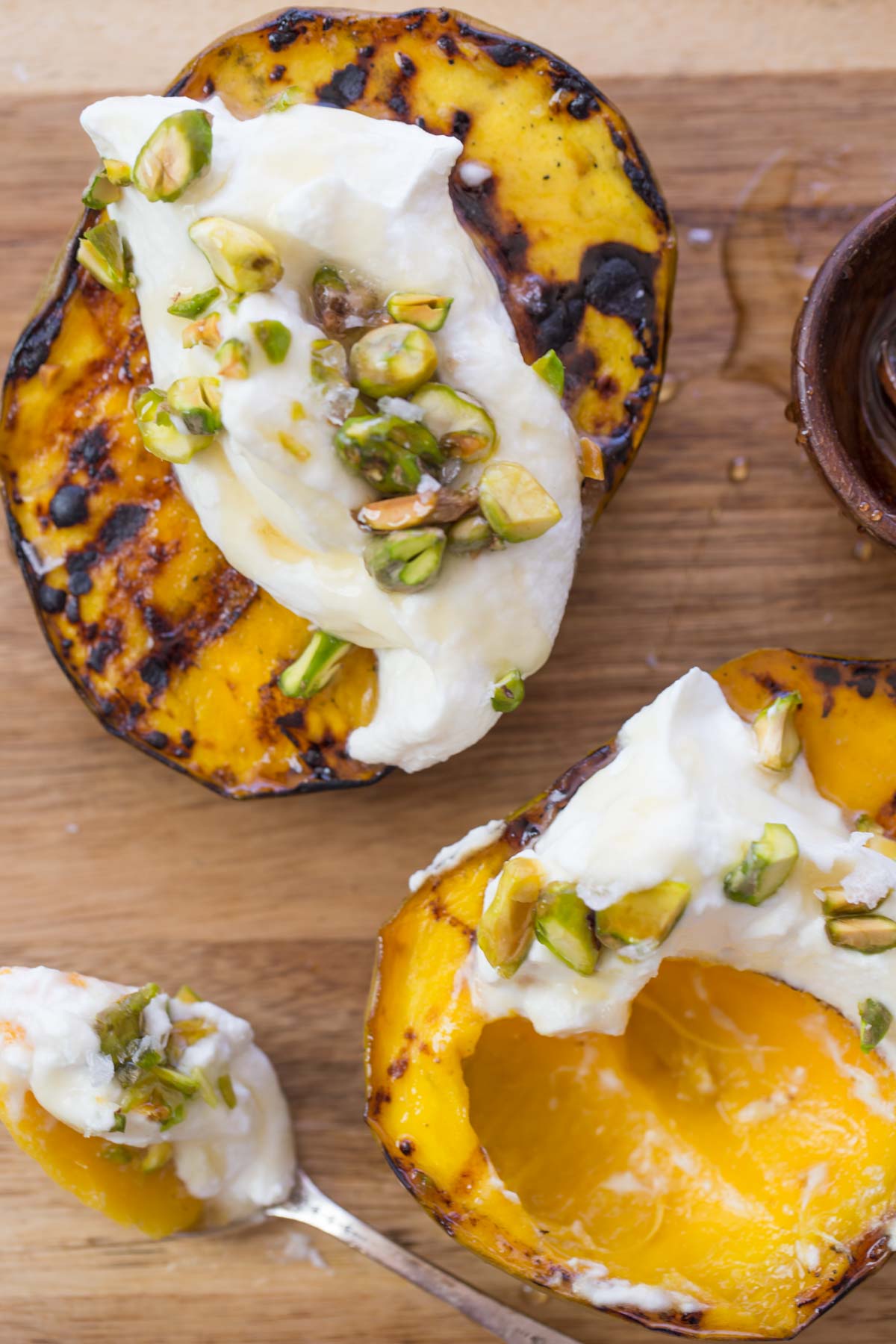 Grilled Mango With Honey Ricotta Whipped Cream on a wooden board.