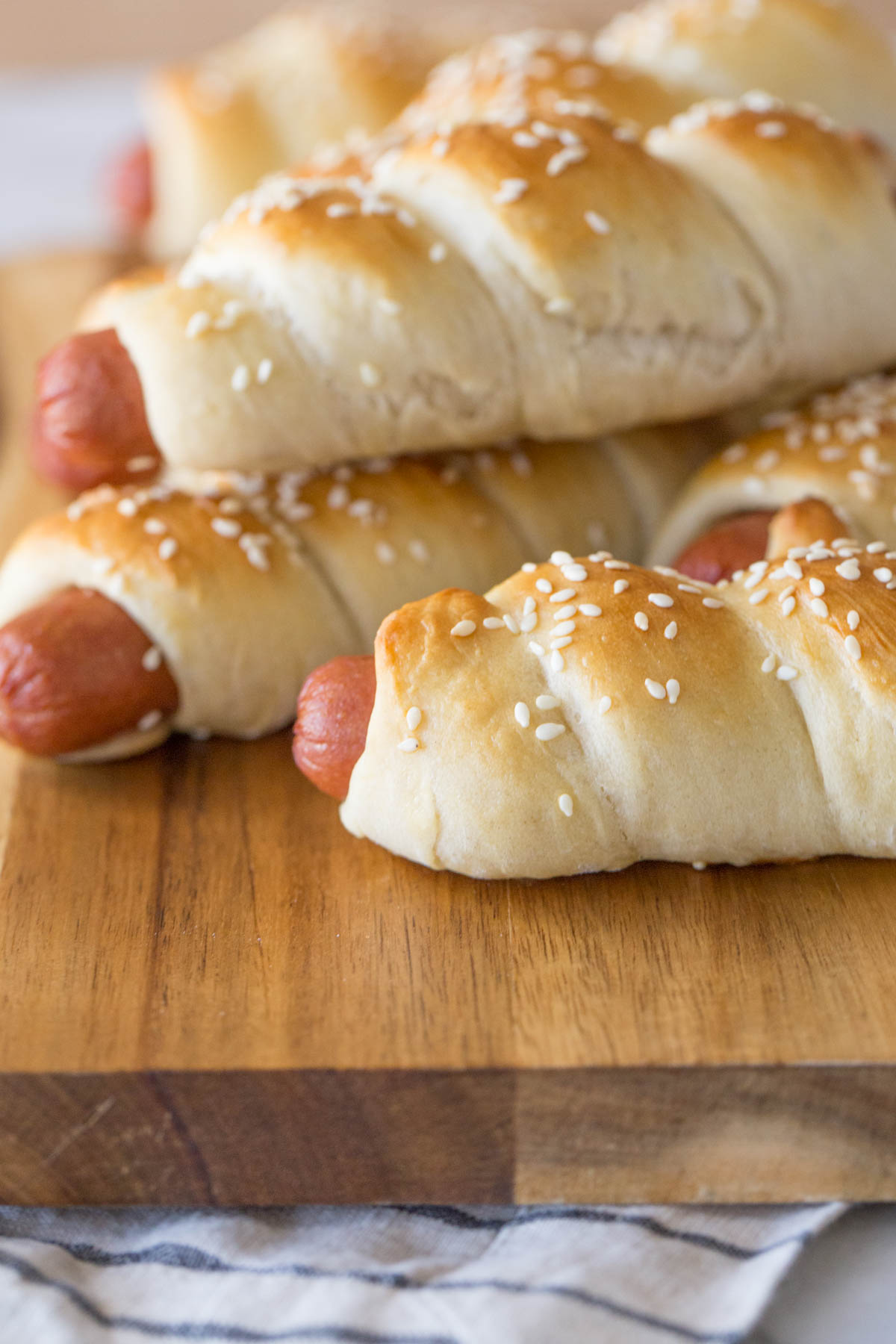 Homemade Pigs in a Blanket on a wooden cutting board.