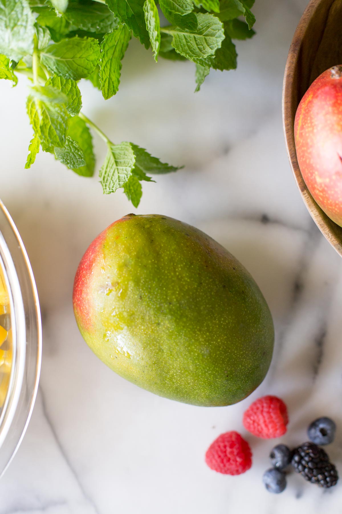 A fresh mango on a marble slab.