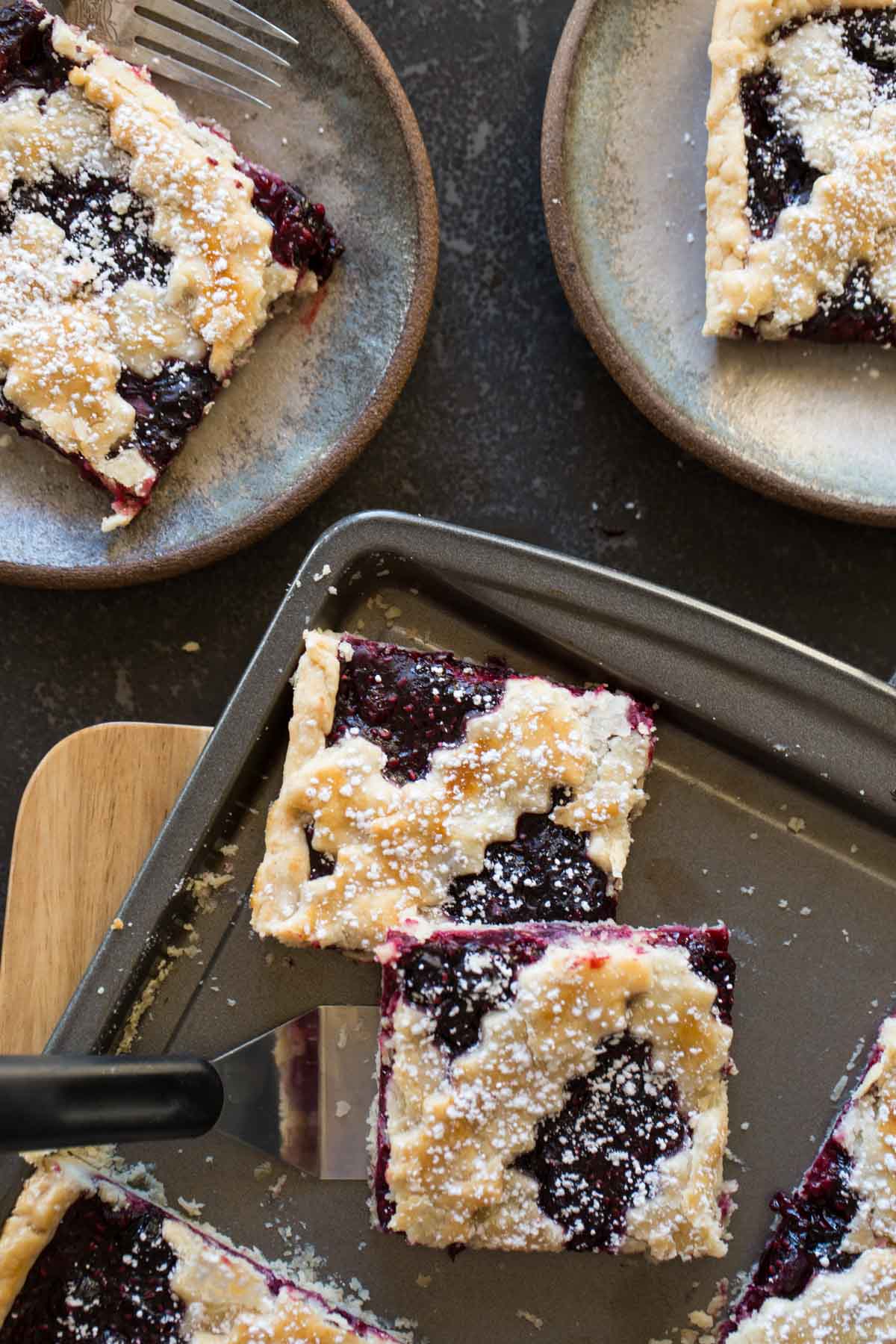 Triple Berry Slab Pie cut into squares and served on two dessert plates.