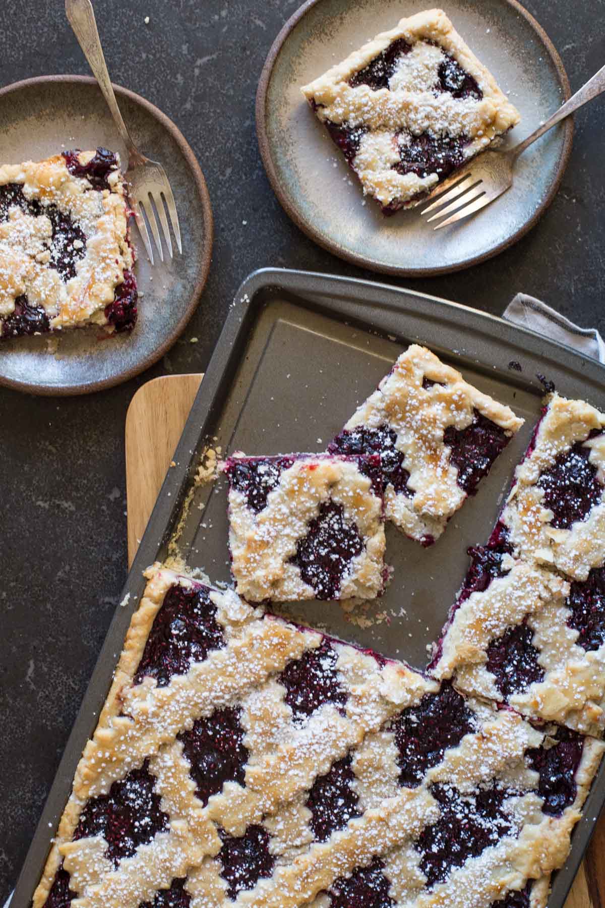 Triple Berry Slab Pie cut into squares and served on two dessert plates.