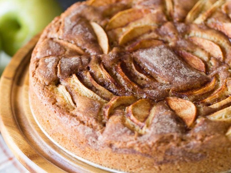 Front view of Apple Cider Cake on a wooden cake stand.