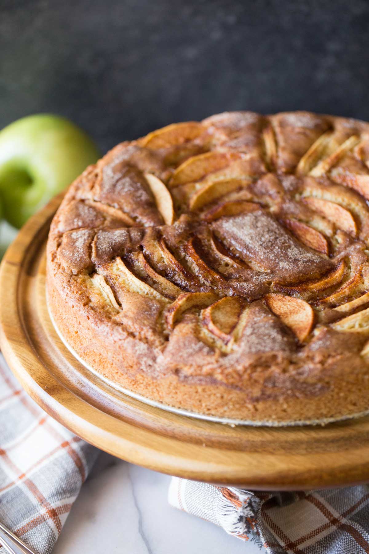 Front view of Apple Cider Cake on a wooden cake stand.