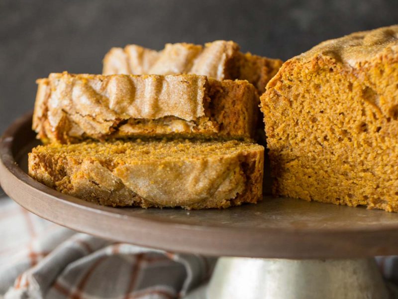 Slices of Easy Pumpkin Bread on a metal cake stand.