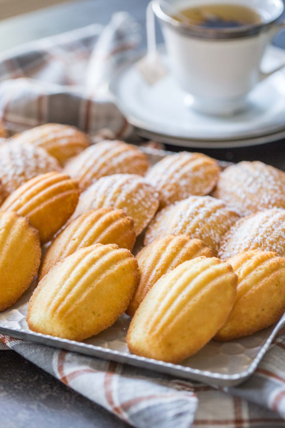 Platter of Lemon Vanilla Madeleines on a plaid tea towel. 