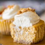 Close up shot of the inside of pumpkin spice cheesecakes topped with whipped cream