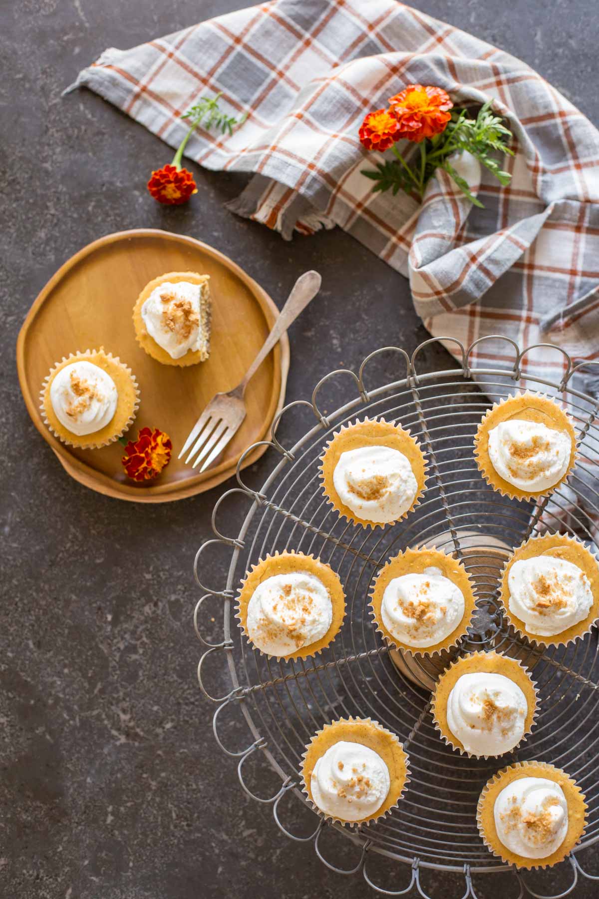 Top down view of Mini Pumpkin Spice Cheesecakes on a cake server and plate with whipped cream on top.