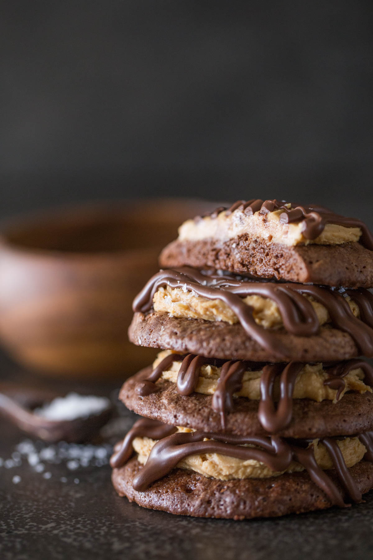 Stack of Peanut Butter Buckeye Brownie Cookies on a grey background. 