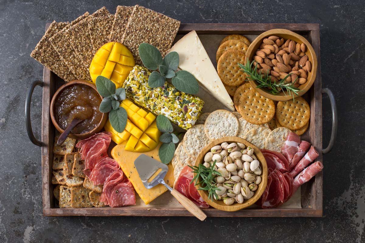Overhead view of Pistachio Crusted Cheese Log displayed as part of a charcuterie.
