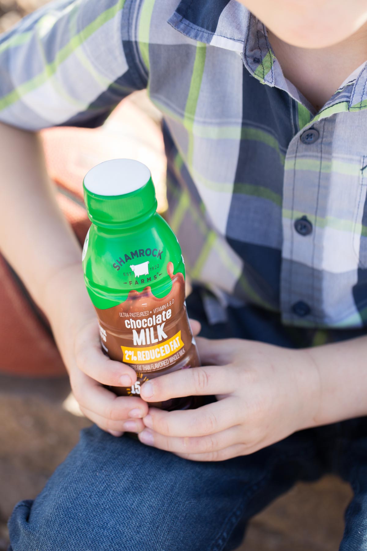 Close up of Shamrock Farms chocolate milk in his hand.