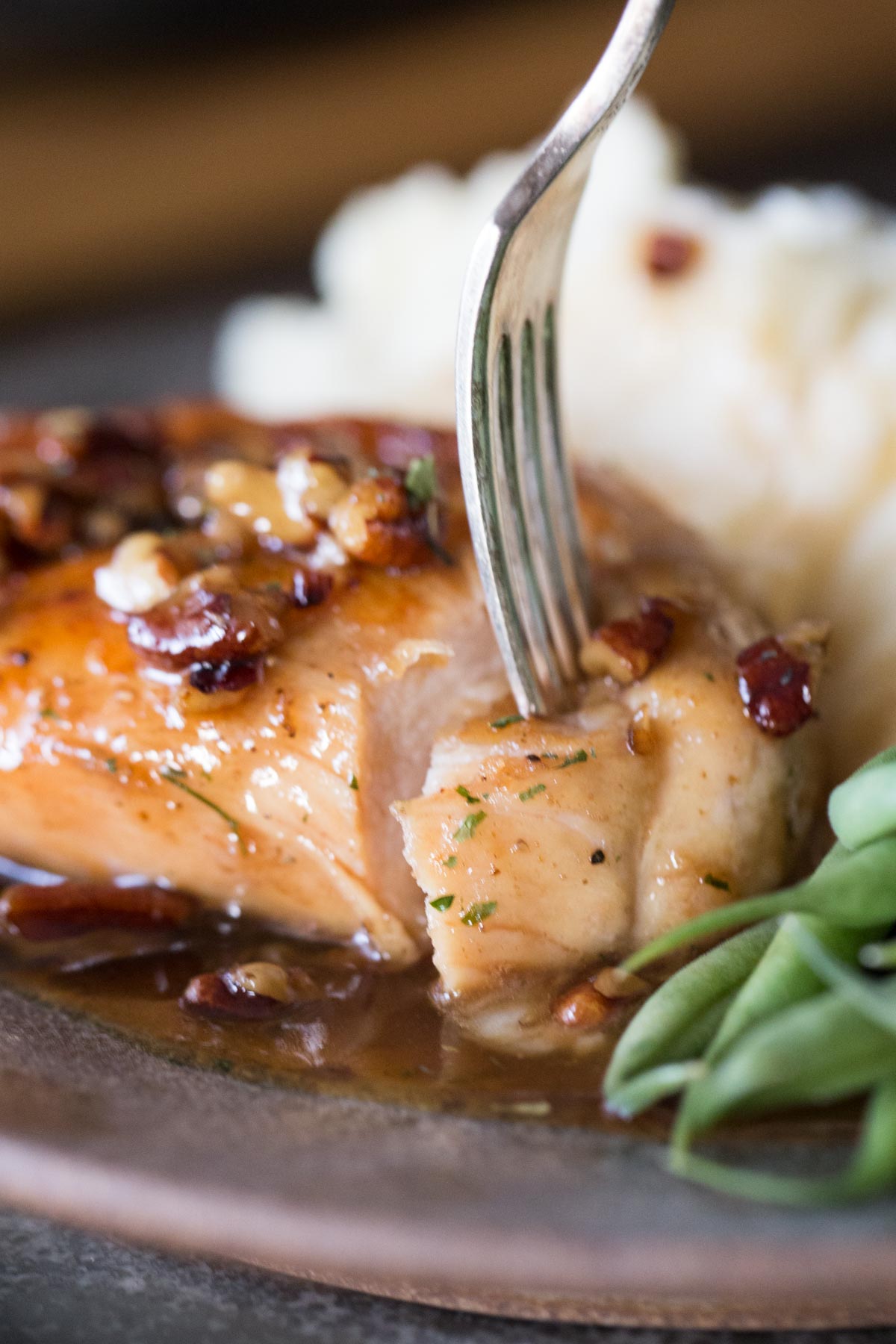 Close up view of bite cut out of Butter Pecan Chicken with a fork. 