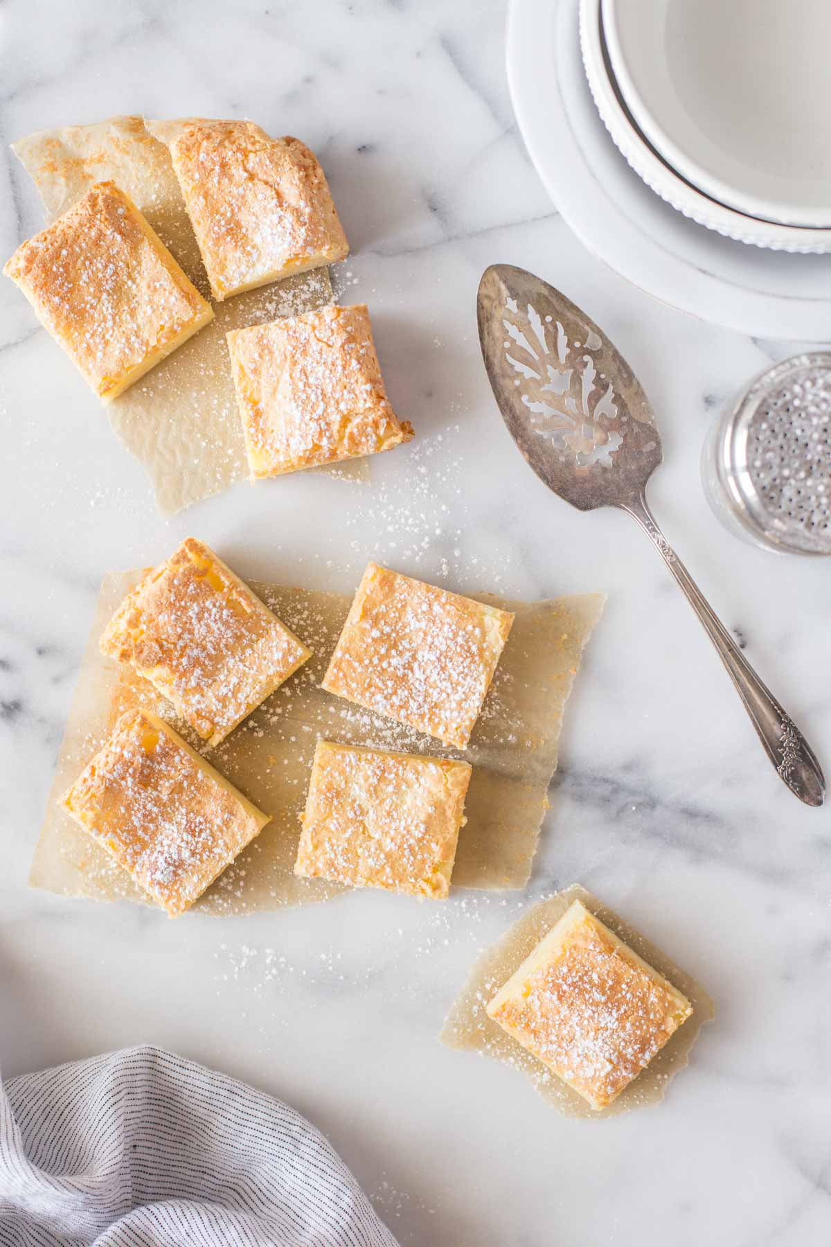 Overhead shot of Gooey Butter Bars cute into squares on a marble background.