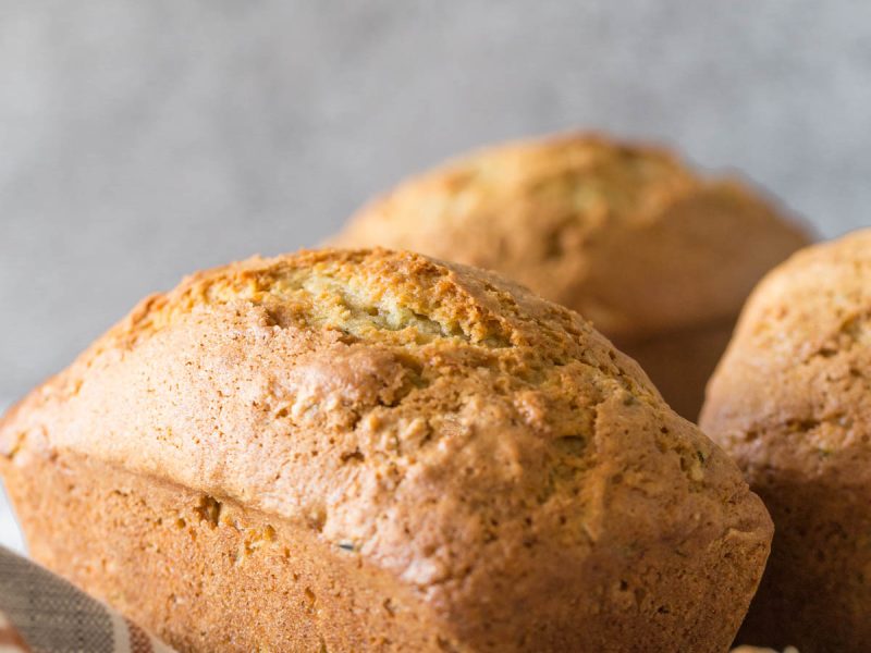 Applesauce Zucchini Bread mini loaf on a grey background.