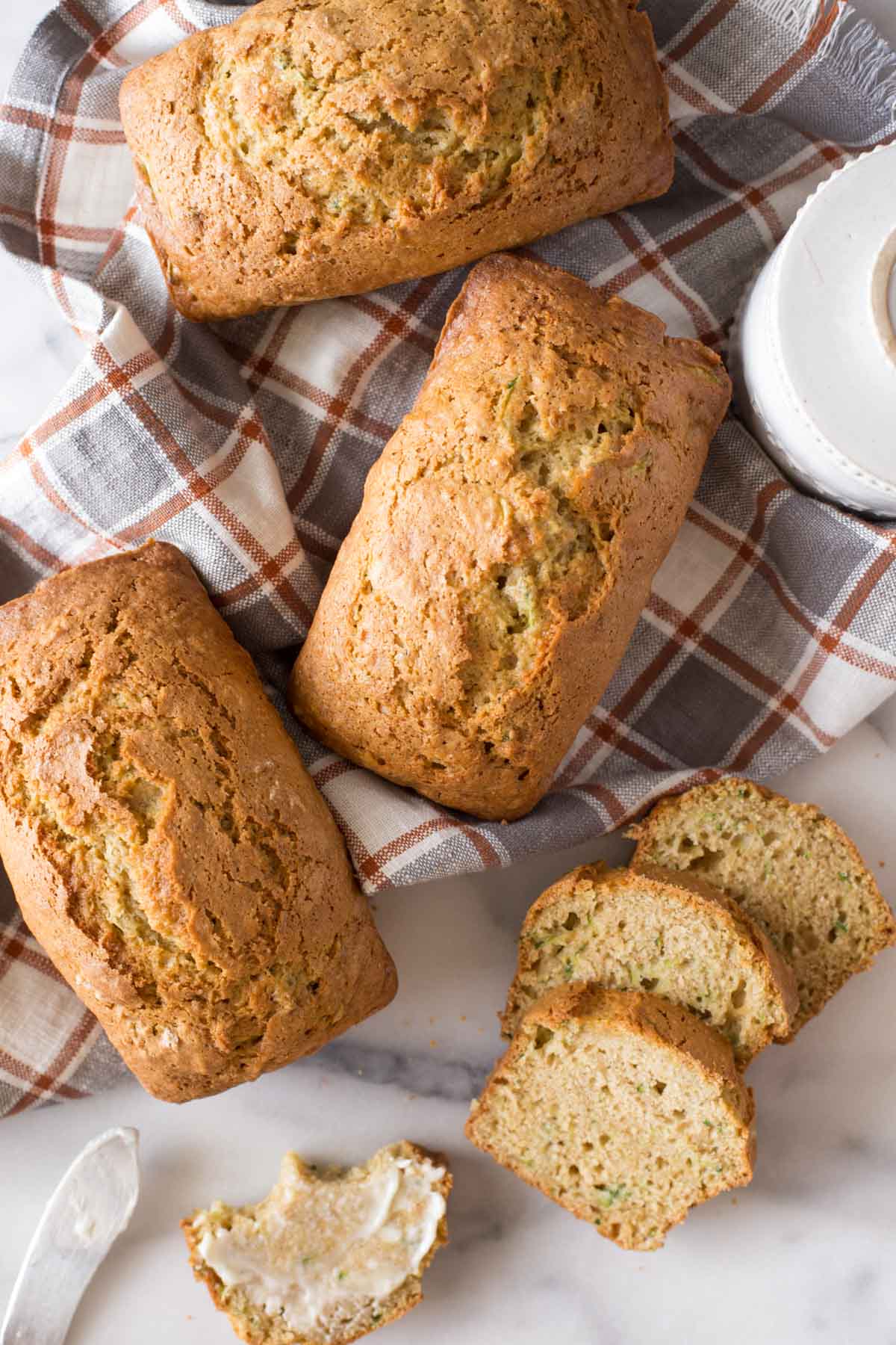Overhead view of Applesauce Zucchini Bread loaves on a marble board. 