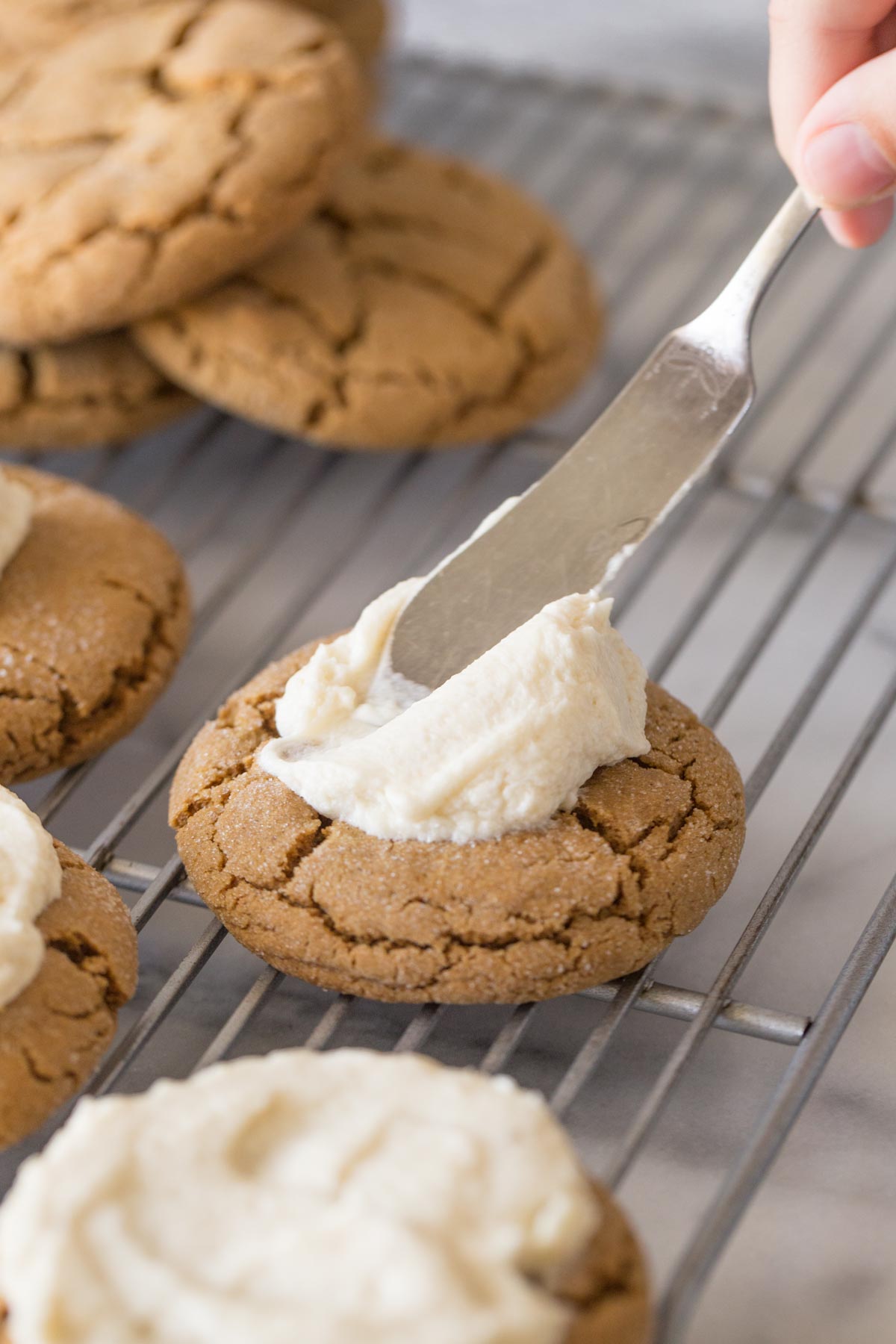 Close up view of Bakery Style Molasses Cookie being frosted. 