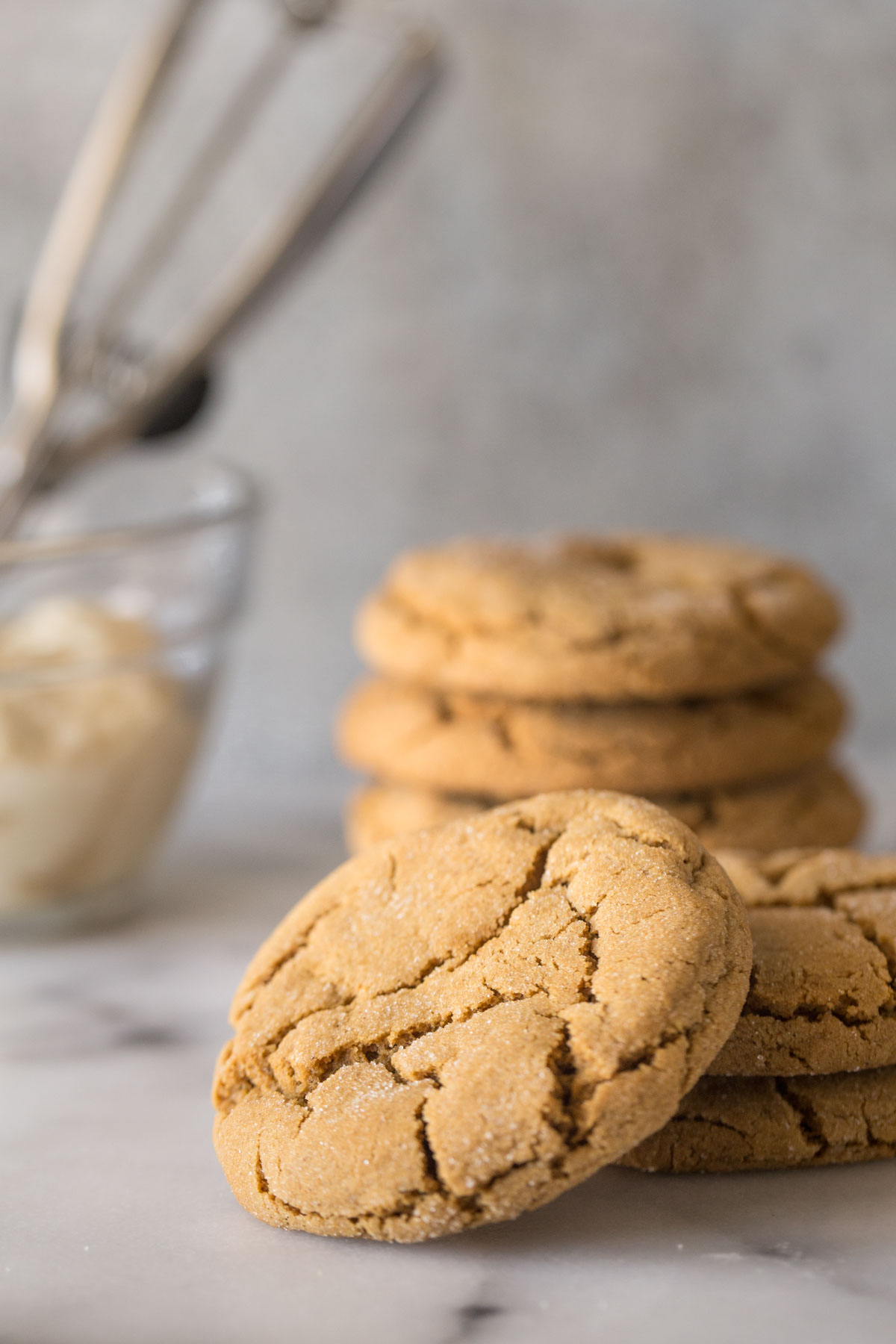 Bakery Style Molasses Cookies stacked on a white marble board. 