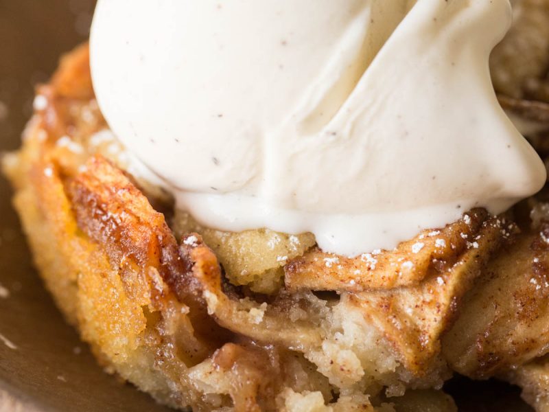 Close up view of Apple Cobbler with a scoop of vanilla ice cream on top.