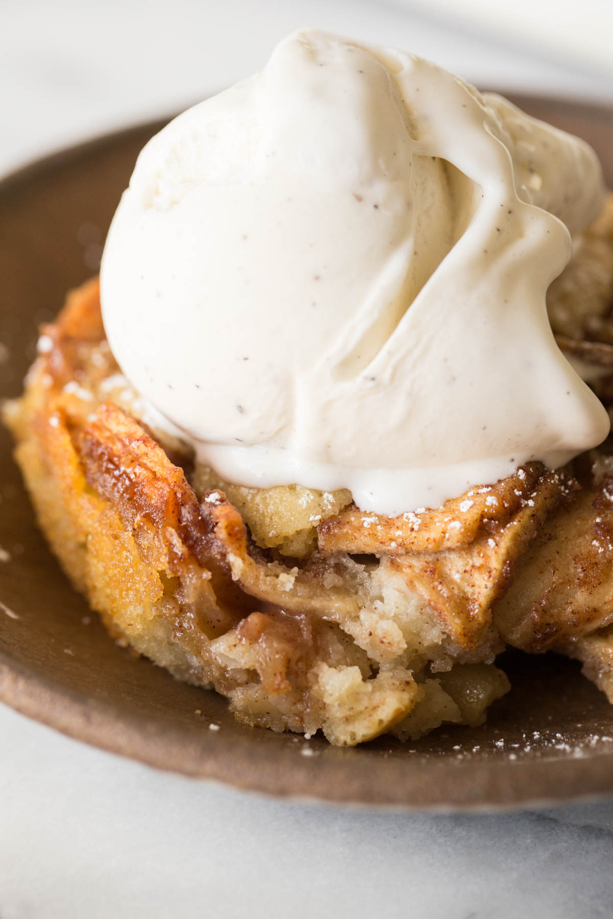 Close up view of Apple Cobbler with a scoop of vanilla ice cream on top.
