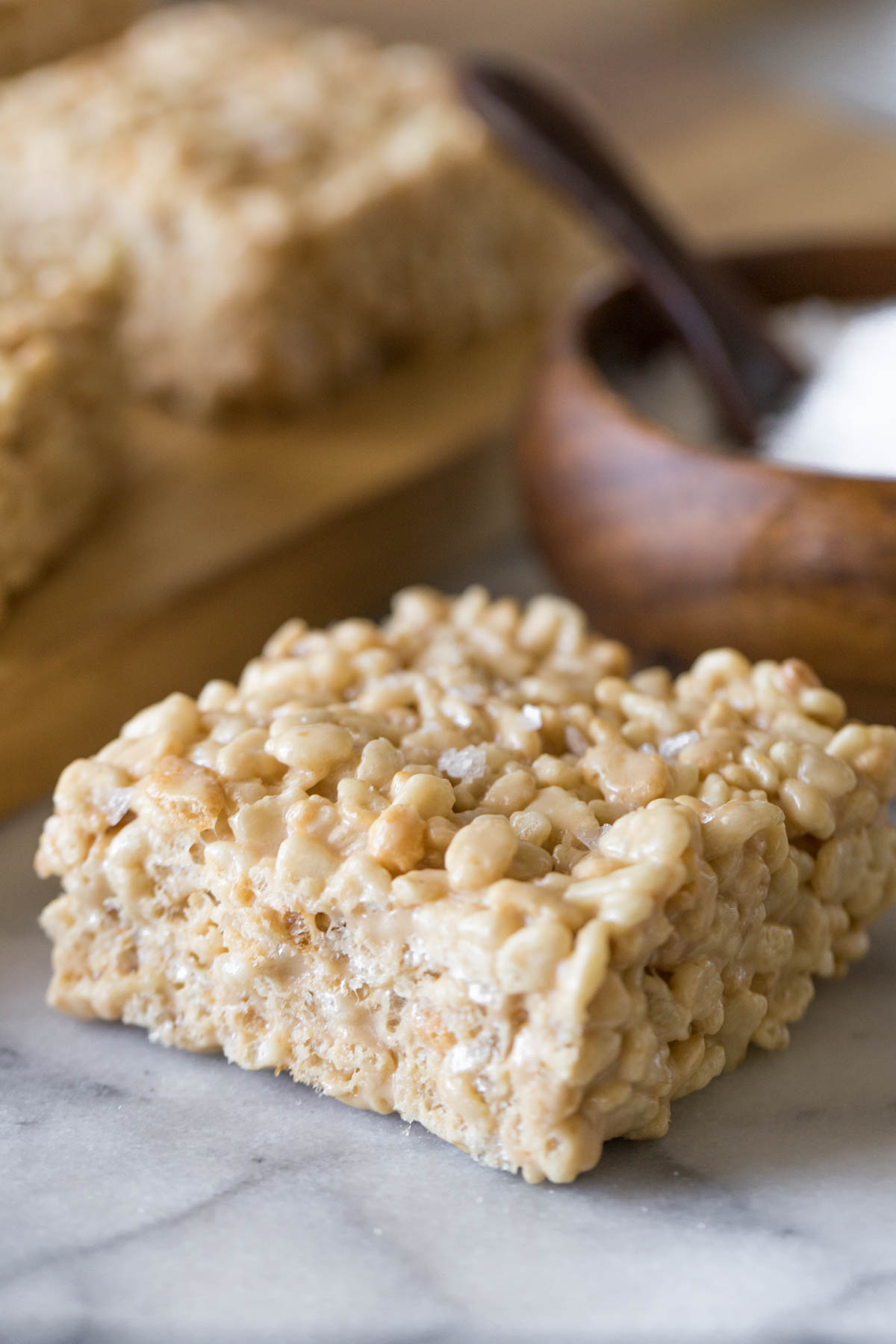Close up view of Salted Caramel Rice Krispie Treat on a marble board.