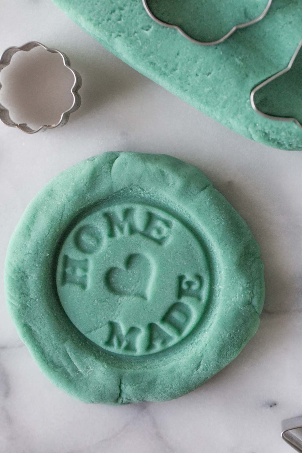 Blue homemade playdough with the words home made stamped into it.