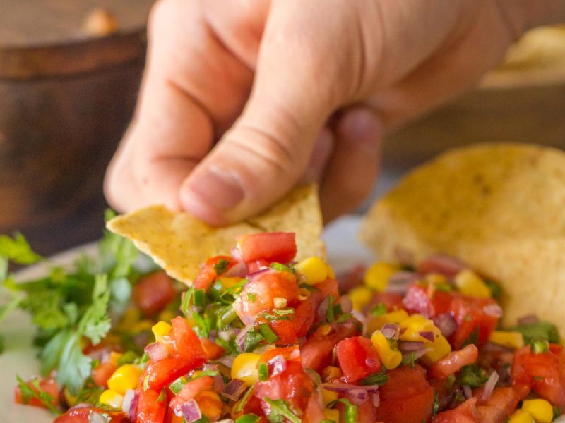 Chip scooping out Homemade Pico de Gallo.