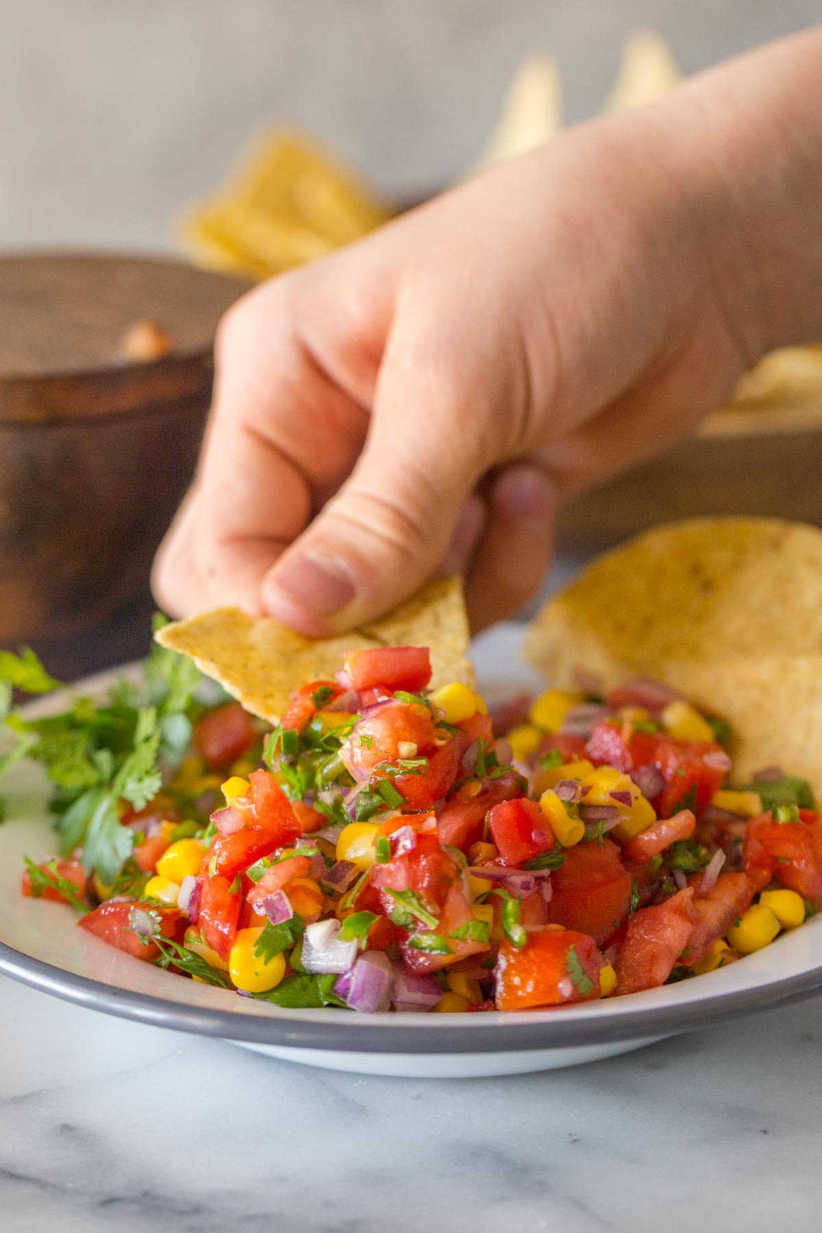 Chip scooping out Homemade Pico de Gallo.