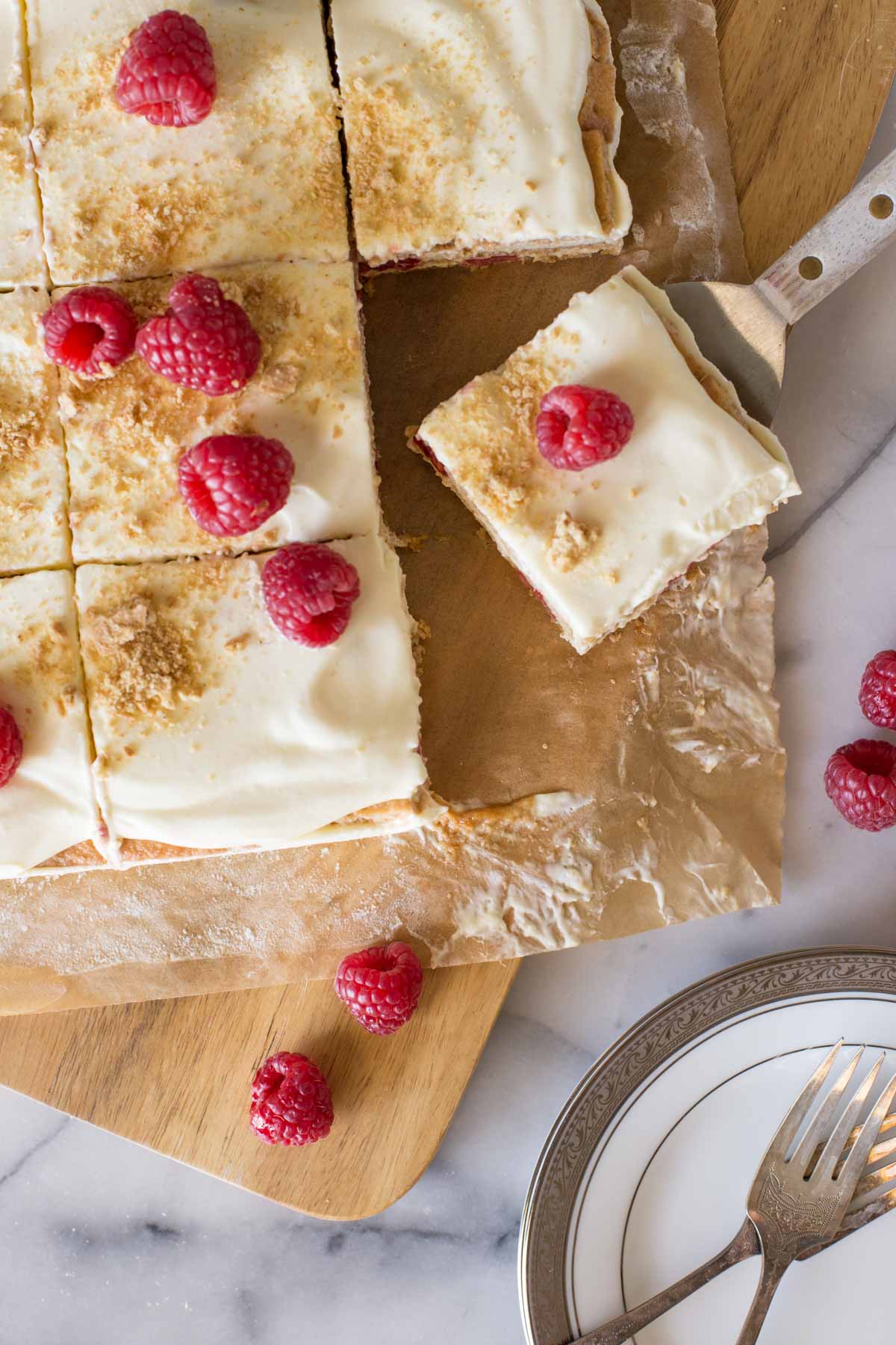 Overhead view of Raspberry Icebox Cake cut, with one piece on a serving spatula. 