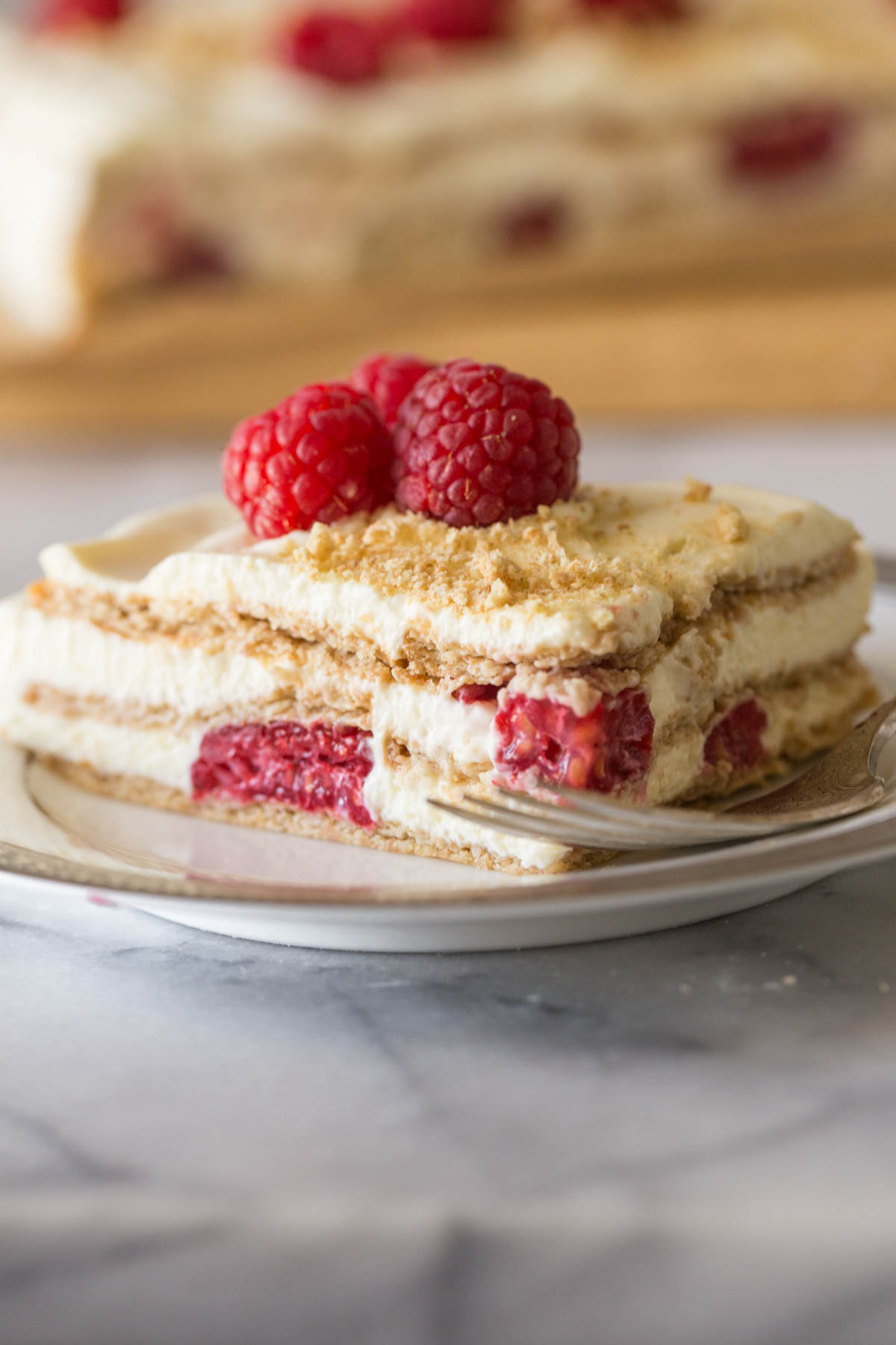 Close up shot of a piece of Raspberry Icebox Cake on a plate with a fork.  