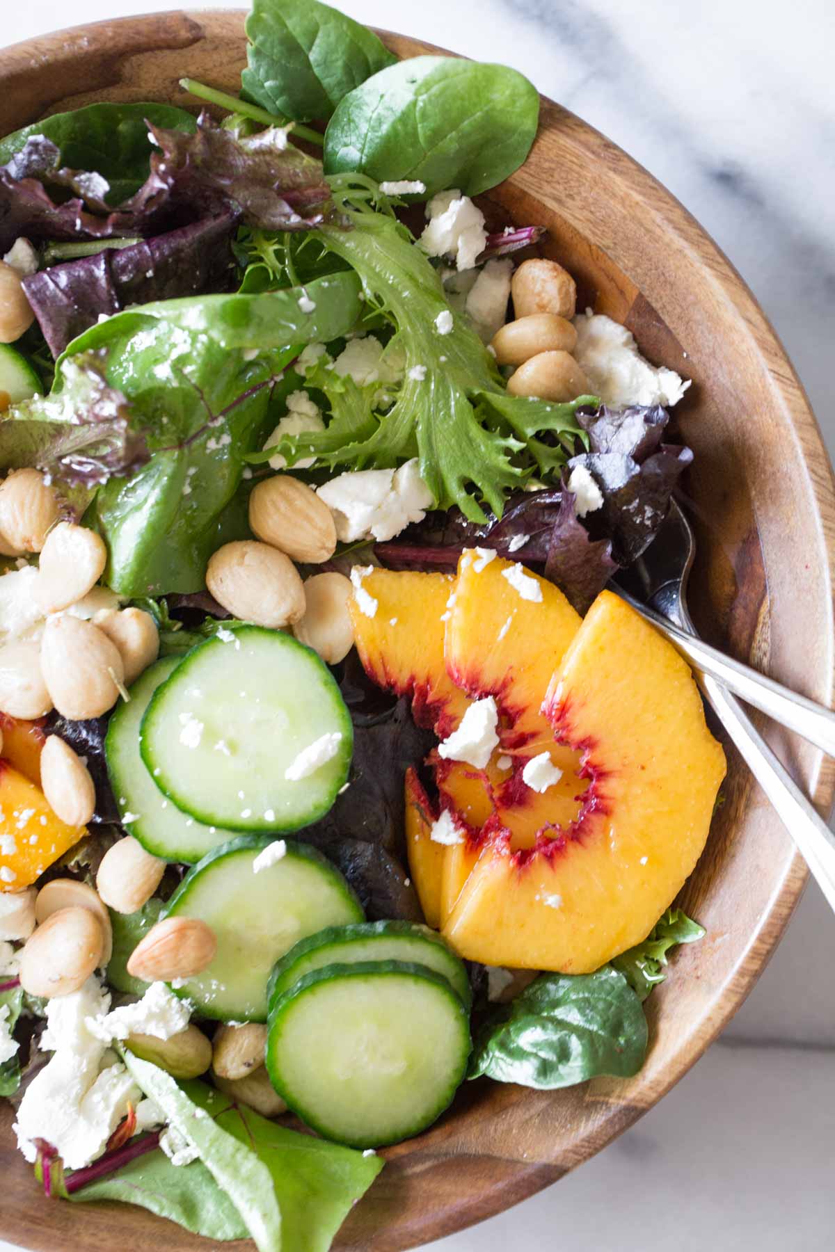 Close up shot of Summer Peach Salad in a wood bowl.
